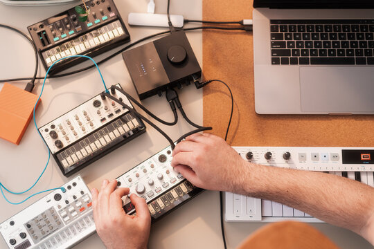 Overhead View Of Anonymous Man Making Music With Synthesizers