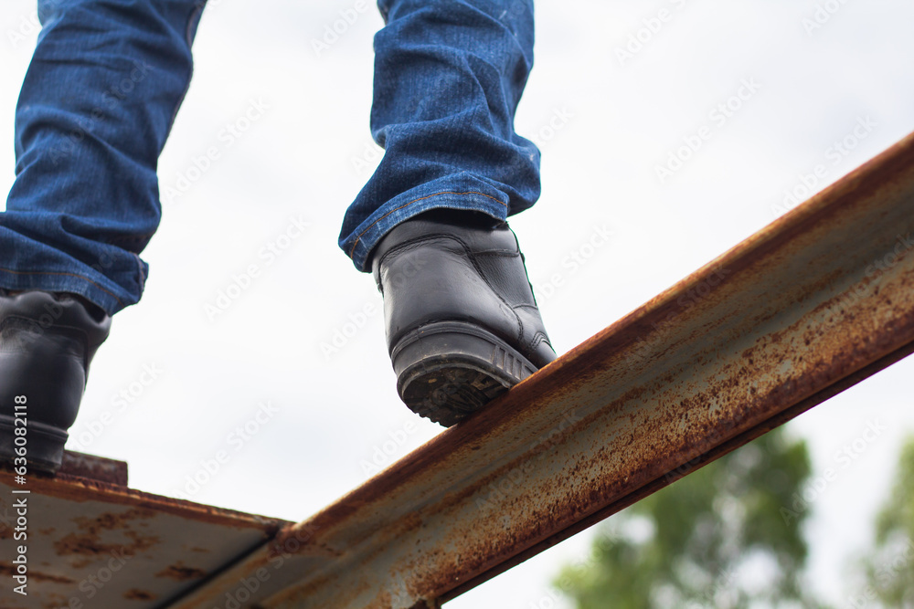 Wall mural Wear safety shoes to ensure safety at work. construction workers wear safety shoes. People with factory safety concept