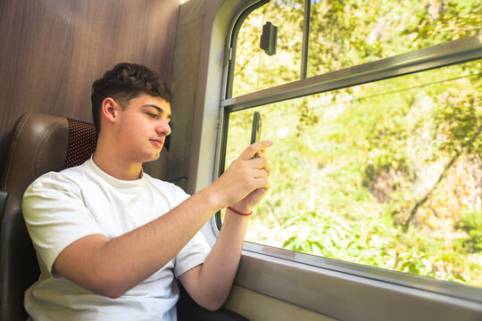 Young man taking a picture in a train