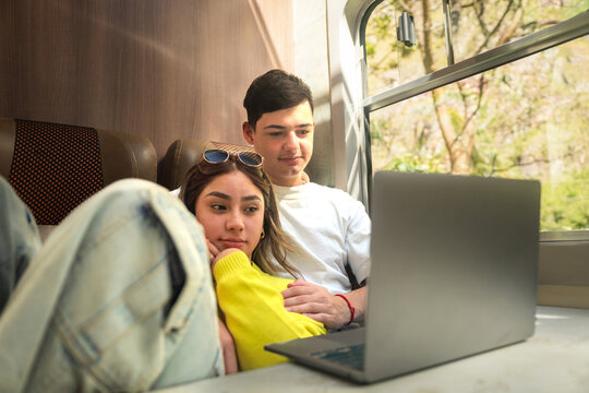 Young couple watching a movie while traveling by train