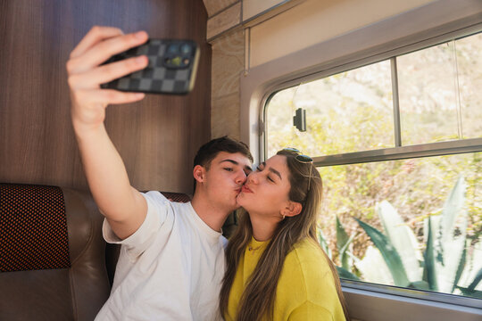 Young couple taking a selfie in a train