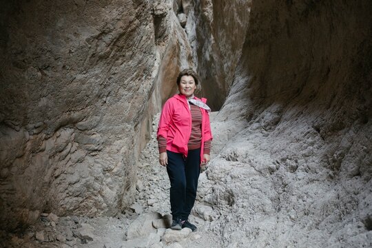woman stands in the midst of a canyon landscape