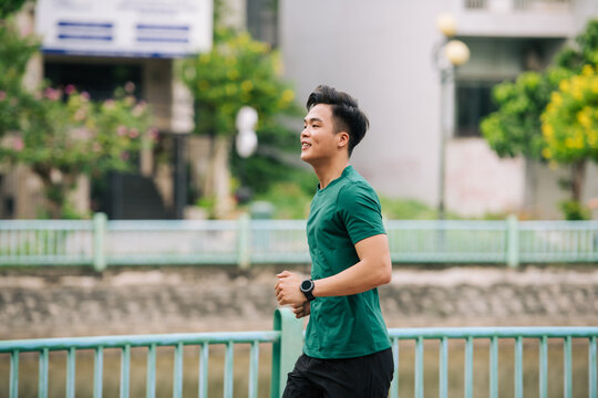 active young asian man jogging at the park in the morning