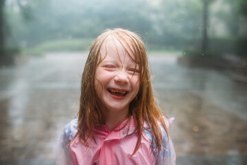 Portrait of little girl smiling in the rain