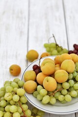 Apricots and grapes, on a white wooden table, free space, place for text, background image for presentations, background, summer