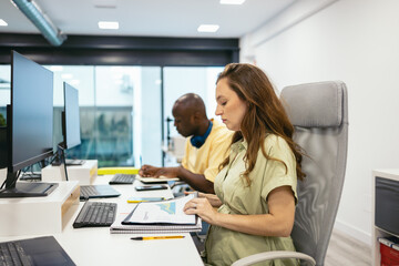 Pregnant woman working in a modern office with her coworkers