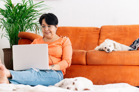 Woman sitting on the floor at home using a computer.