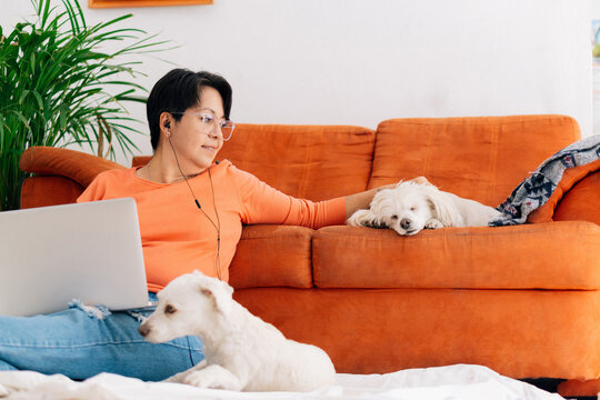 Mature woman working at home with her pets.
