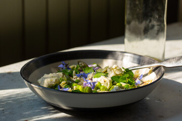 spring vegetable salad with pasta and edible flowers. 