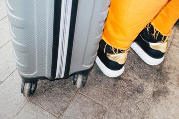 Travel suitcase near waiting person