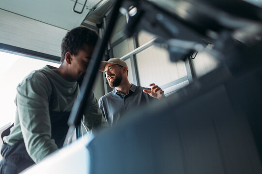 Two Mechanics Repairing Car