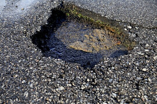 Damaged roadways with pot hole in the asphalt 