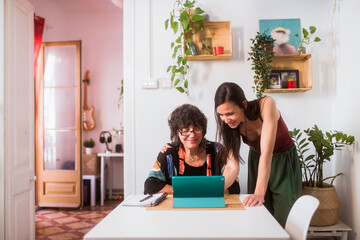 Smiling daughter teaching mother how to use a tablet