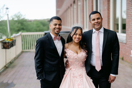 teen girl posing with her brothers during her Quinceanera