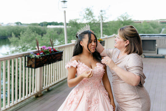 mother fixed daughter's hair during
 during her Quinceanera