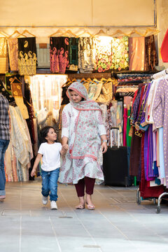 Indian mother walking through store with son