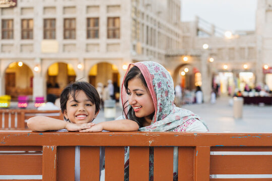 Indian mother and son sitting on bench