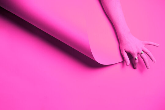 Pink painted hand on a pink background. Pink on pink
