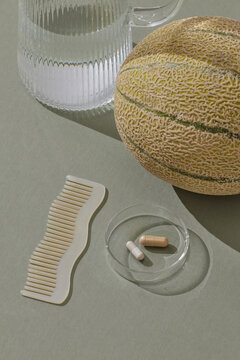 Styled Still Life: Melon, Supplements, Wavy Comb, and Glass of Water