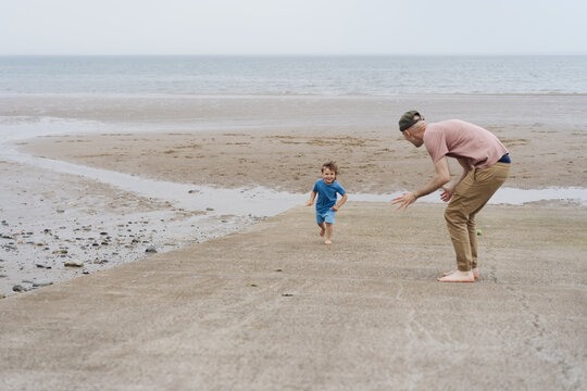 Father playing with little boy on the beach