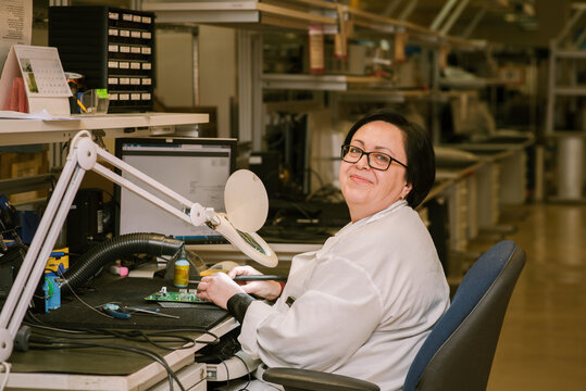 Skilled and Confident Woman Soldering Electronic Circuit Board.