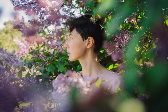 Portrait of a woman among lilac bloom