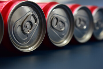 close up group of aluminium red cans soft drink put on blue texture background