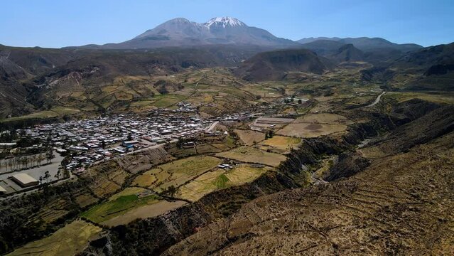 Aerial view towards small town in the altiplano, sunny evening, Putre,  Chile - dolly, drone shot