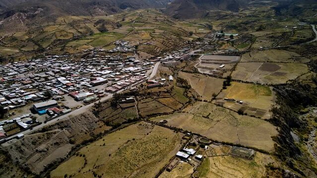 Aerial view towards small town in the altiplano, sunny evening, Putre,  Chile - reveal, drone shot