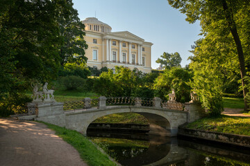 Obraz premium Centaur Bridge in Pavlovsky Park against the background of the Pavlovsky Palace on a sunny summer day, garden and park reserve in St. Petersburg, Russia
