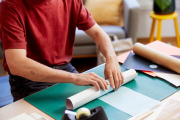 Cropped image of male rolling finished paper placard