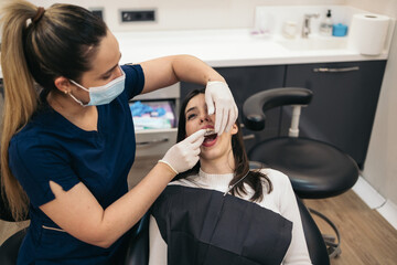 Female Dentist Putting Invisible Orthodontics To Client
