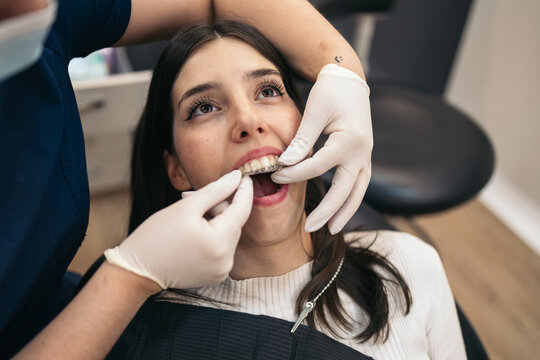 Young woman having invisible braces put on at the dentist