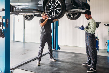 Two Mechanics Repairing Car in Garage 