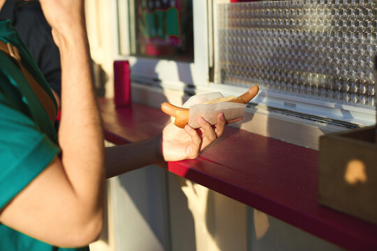  Man holding a hotdog in front of food truck