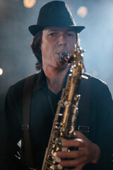 Portrait of man who plays saxophone and looks at camera