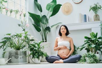 Beautiful pregnant woman practicing yoga at terrace