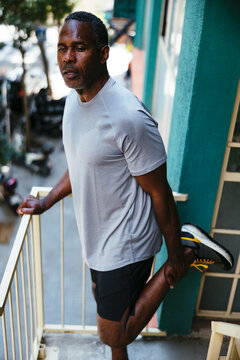 Serious sport mature man standing on a balcony