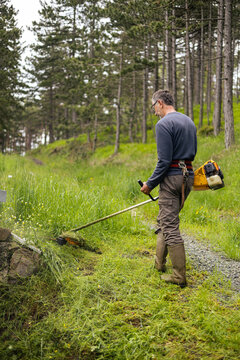 Man cuts the grass on a mountain