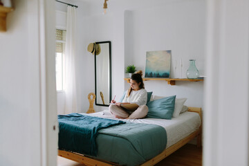 Woman studying in a modern bedroom