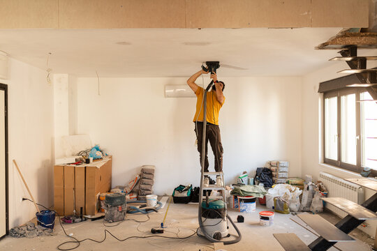 Electrician cuts a channel in the ceiling