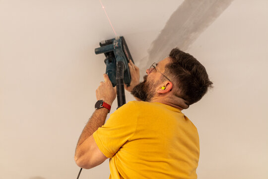 Electrician cuts a channel in the ceiling