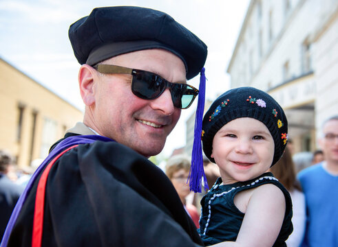 Non-traditional Student Holds Baby Daughter at his Graduation