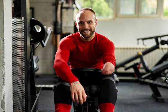 Cheerful disabled athlete sitting at the gym