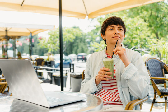 A woman drinks a cocktail in a cafe