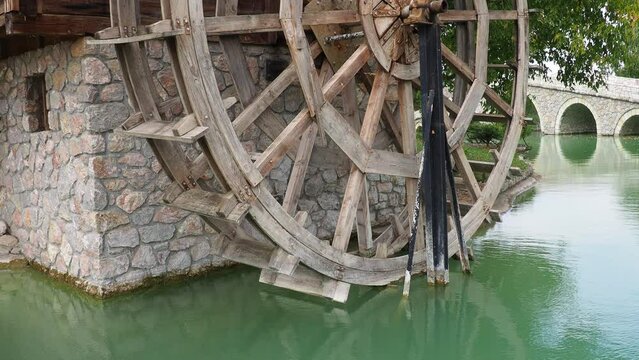 Stanisici Bijelina, Bosnia and Herzegovina, 08.15.23 Wooden water mill. A hydraulic structure using hydropower from a water wheel. Work by means of a gear train. Retro vintage ethno folk architecture.