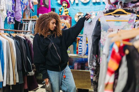 Black Woman Choosing Clothes In Shop