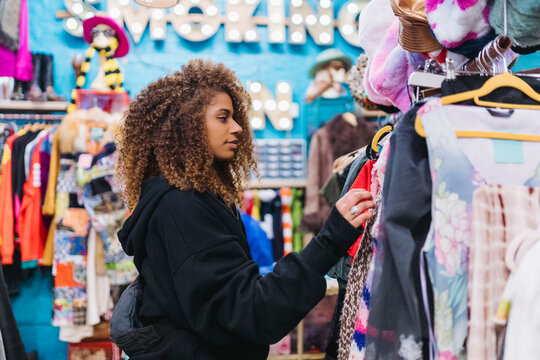 Black woman buying clothes on street market