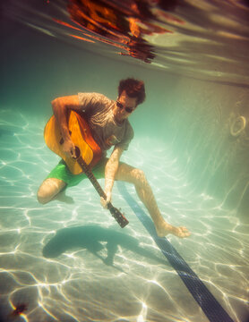 Funny guitarist posing underwater