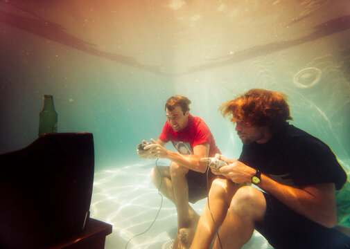 Funny portrait of two friends playing video games in pool